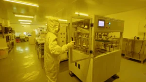 A professional engineering workspace photo showing a dynamic flex PCB undergoing bend testing in a specialized testing fixture.